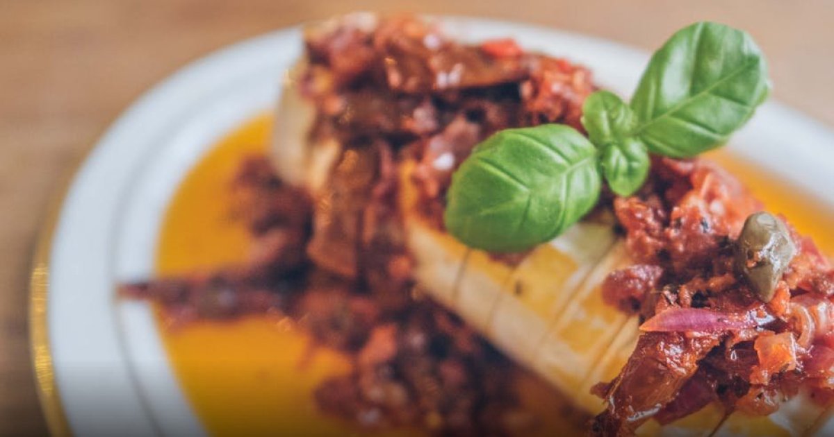 Semangkuk penuh Tumis Ayam Brokoli Saus Tiram yang mengkilap dengan taburan irisan daun bawang segar di atasnya.