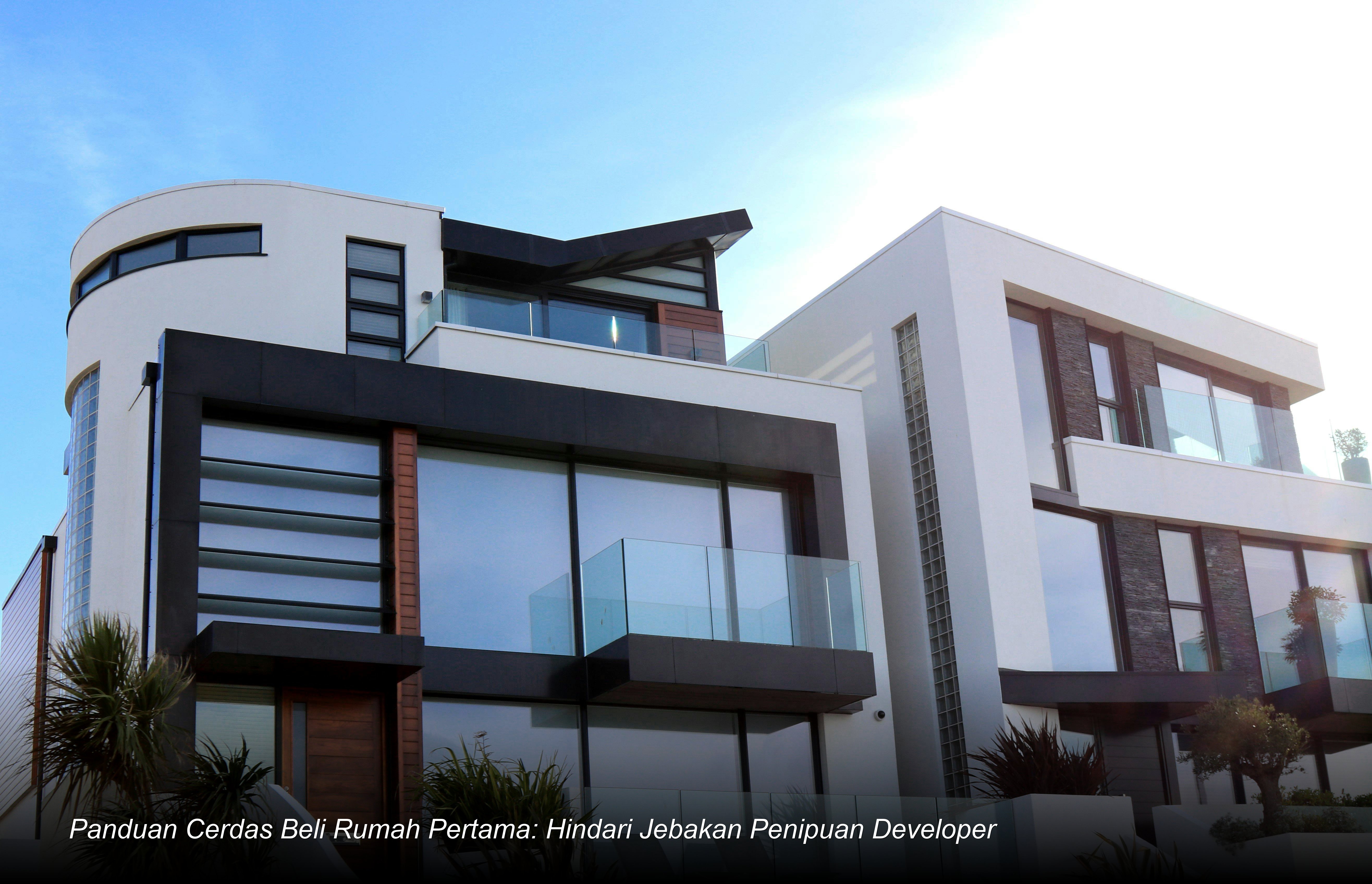 Pasangan muda sedang meninjau dokumen akad kredit KPR dengan seorang analis bank profesional di depan maket rumah minimalis modern.
