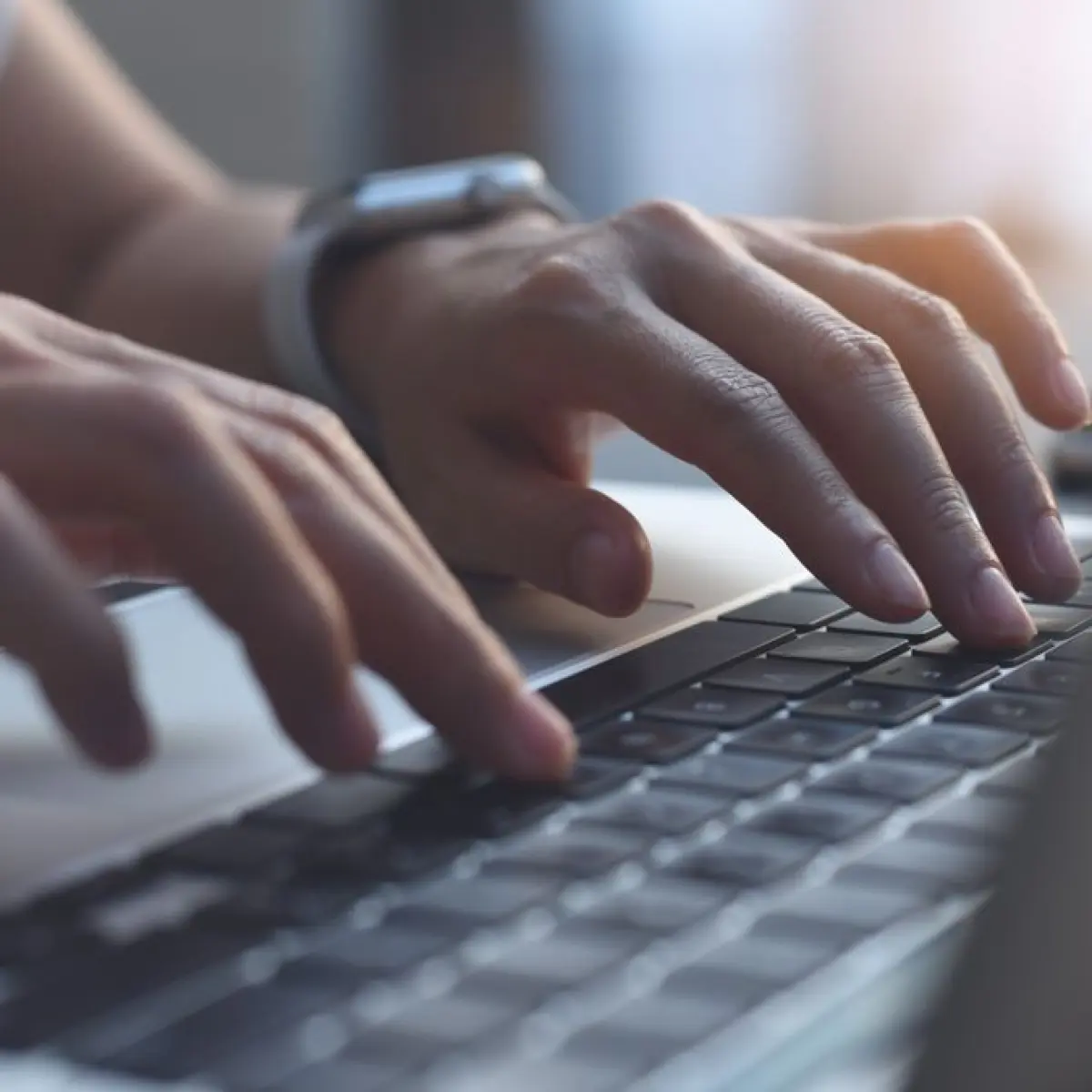 close-up tangan menyentuh keyboard laptop bisnis premium dengan layar menyala terang (Foto: Mos)