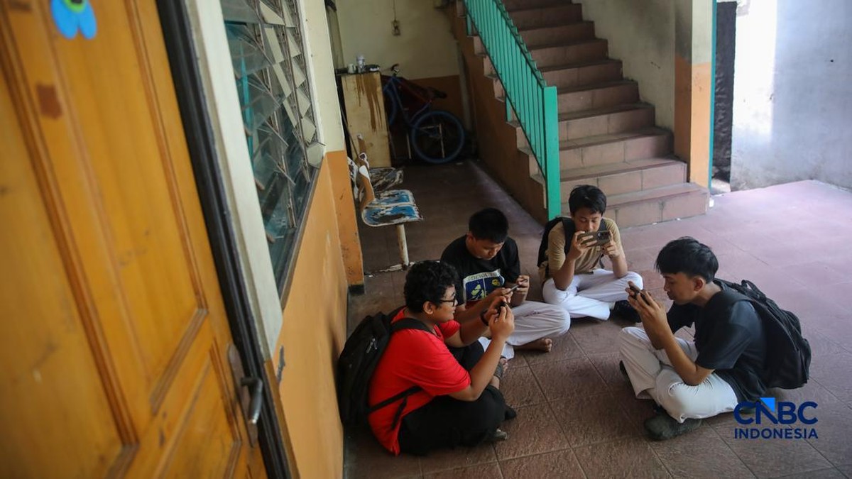 Foto: Sejumlah anak memainkan ponsel mereka sesuai pulang sekolah di Jakarta, Senin (30/3/2026). Pemerintah resmi melarang anak di bawah usia 16 tahun menggunakan media sosial mulai 28 Maret 2026 berdasarkan Peraturan Menteri Komunikasi dan Digital Nomor 9 Tahun 2026, yang merupakan turunan dari PP Tunas. (CNBC Indonesia/Faisal Rahman)