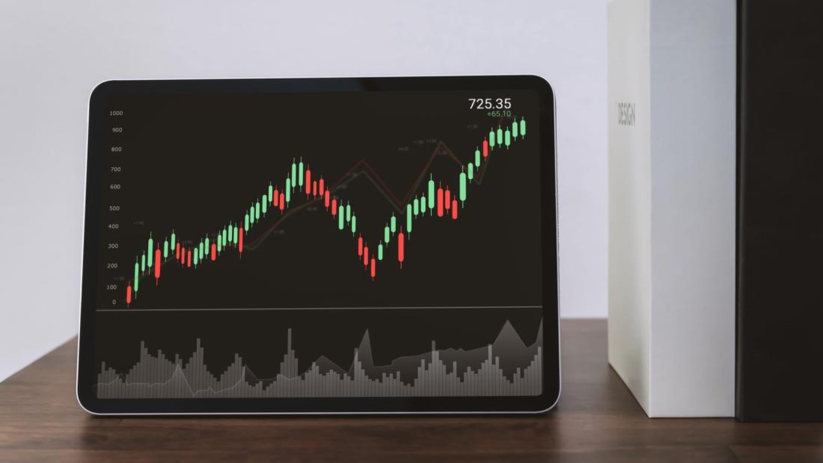 Ilustrasi grafik saham dalam latar belakang hitam pada layar tablet
