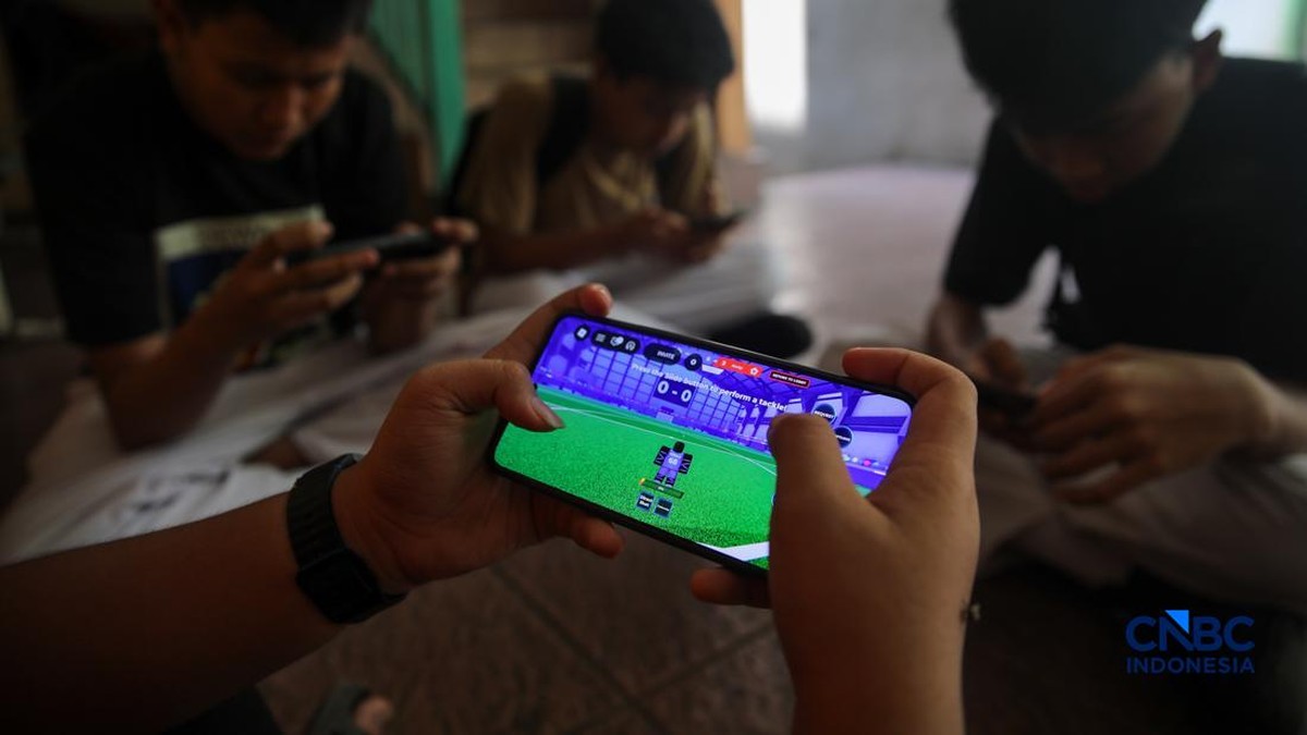 Foto: Sejumlah anak memainkan ponsel mereka sesuai pulang sekolah di Jakarta, Senin (30/3/2026). Pemerintah resmi melarang anak di bawah usia 16 tahun menggunakan media sosial mulai 28 Maret 2026 berdasarkan Peraturan Menteri Komunikasi dan Digital Nomor 9 Tahun 2026, yang merupakan turunan dari PP Tunas. (CNBC Indonesia/Faisal Rahman)