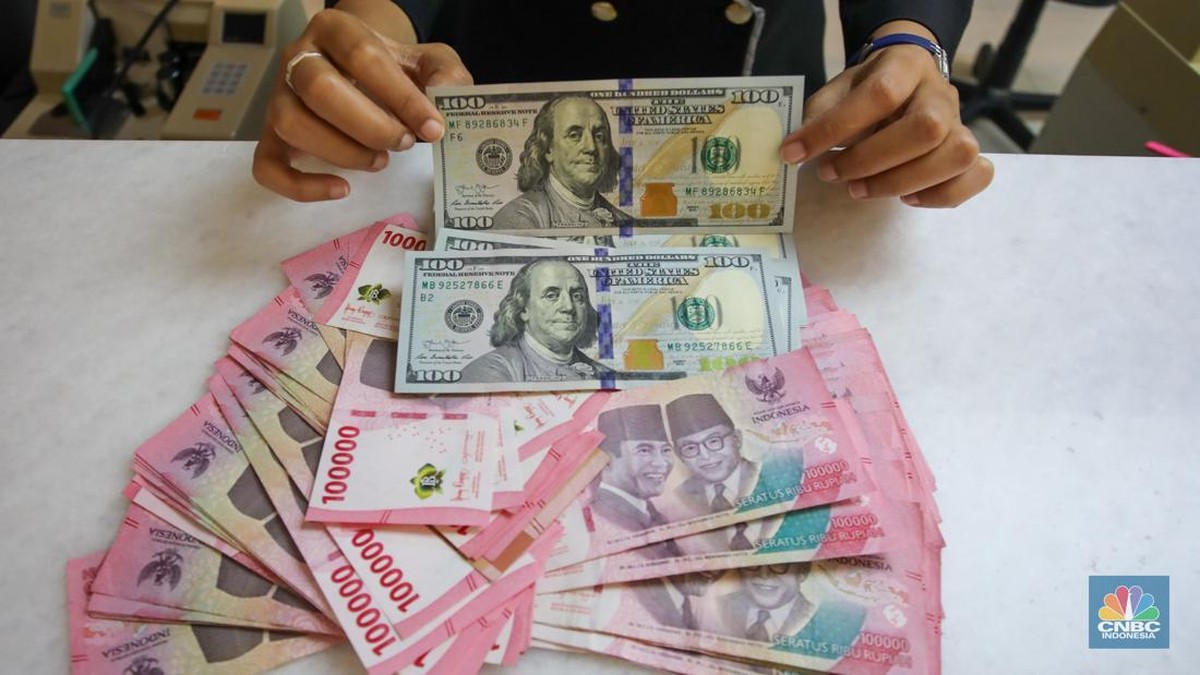 Foto: Petugas menunjukkan uang pecahan dolar AS dan rupiah di gerai penukaran mata uang asing di tempat penukaran uang PT Ayu Masagung, Jakarta, Senin (18/11/2024). (CNBC Indonesia/Faisal Rahman)