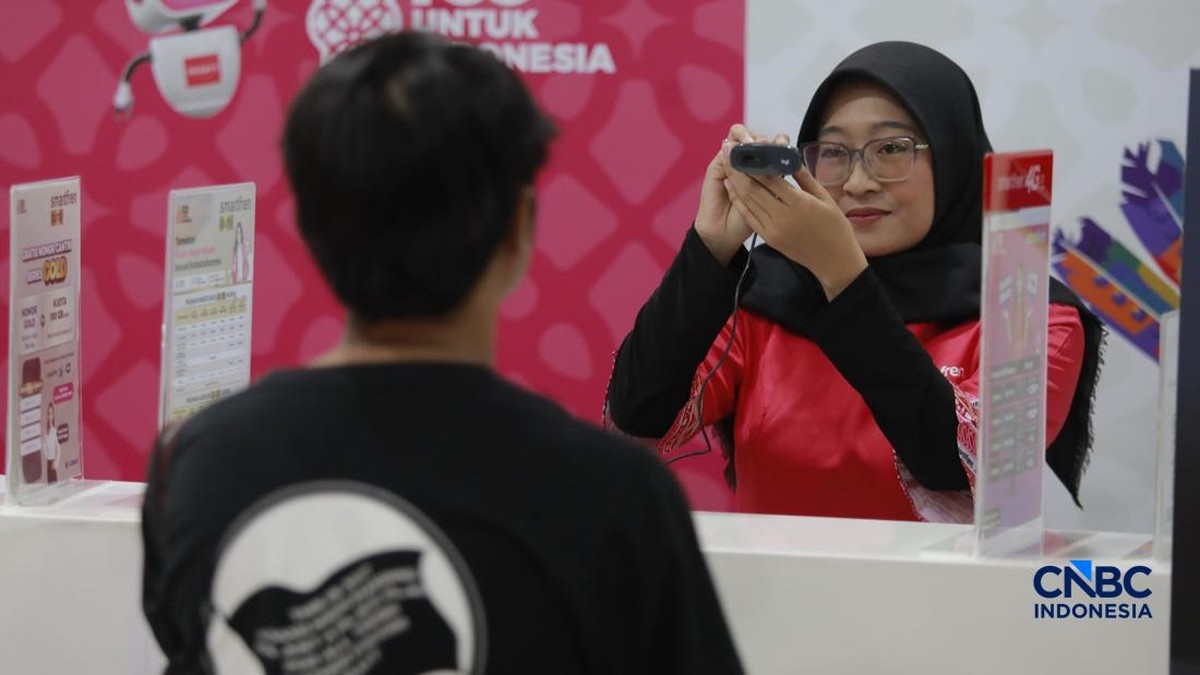 Seorang pengunjung melakukan sistem registrasi pelanggan layanan telekomunikasi berbasis data biometrik dengan dukungan teknologi pengenalan wajah di counter Smartfren, Mall Ambasador, Jakarta, Rabu, (1/7/2026). (CNBC Indonesia/Muhammad Sabki)