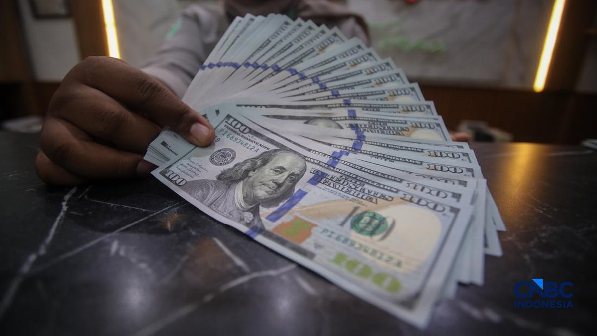 Foto: Petugas menjunjukkan uang pecahan dolar Amerika Serikat (AS) dan rupiah di Dolar Asia Money Changer, Jakarta, Rabu (8/7/2026). (CNBC Indonesia/Faisal Rahman)