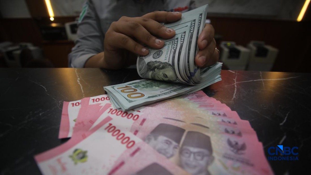Foto: Petugas menjunjukkan uang pecahan dolar Amerika Serikat (AS) dan rupiah di Dolar Asia Money Changer, Jakarta, Rabu (8/7/2026). (CNBC Indonesia/Faisal Rahman)