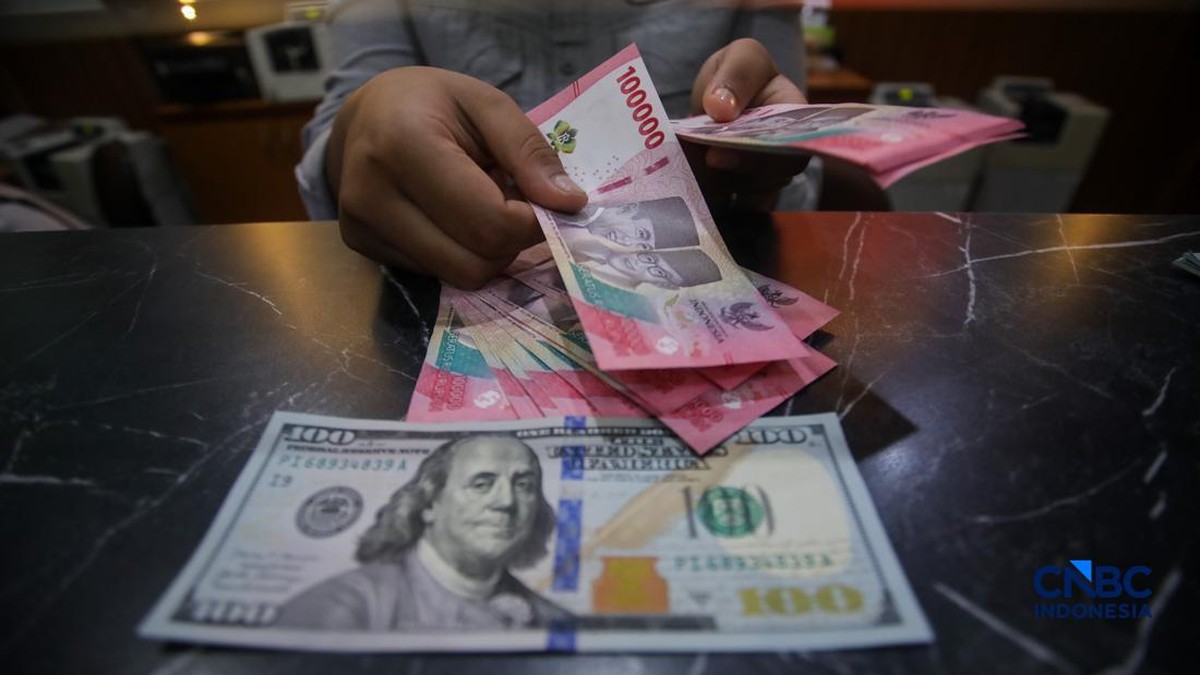 Foto: Petugas menjunjukkan uang pecahan dolar Amerika Serikat (AS) dan rupiah di Dolar Asia Money Changer, Jakarta, Rabu (8/7/2026). (CNBC Indonesia/Faisal Rahman)