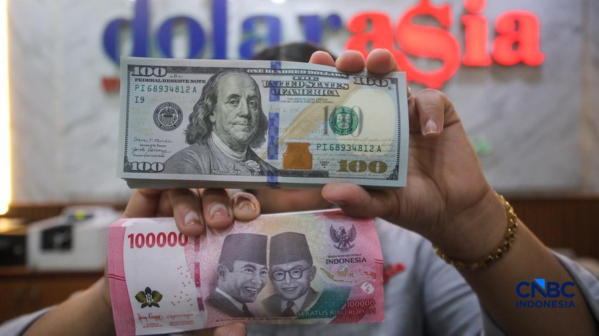 Foto: Petugas menjunjukkan uang pecahan dolar Amerika Serikat (AS) dan rupiah di Dolar Asia Money Changer, Jakarta, Rabu (8/7/2026). (CNBC Indonesia/Faisal Rahman)