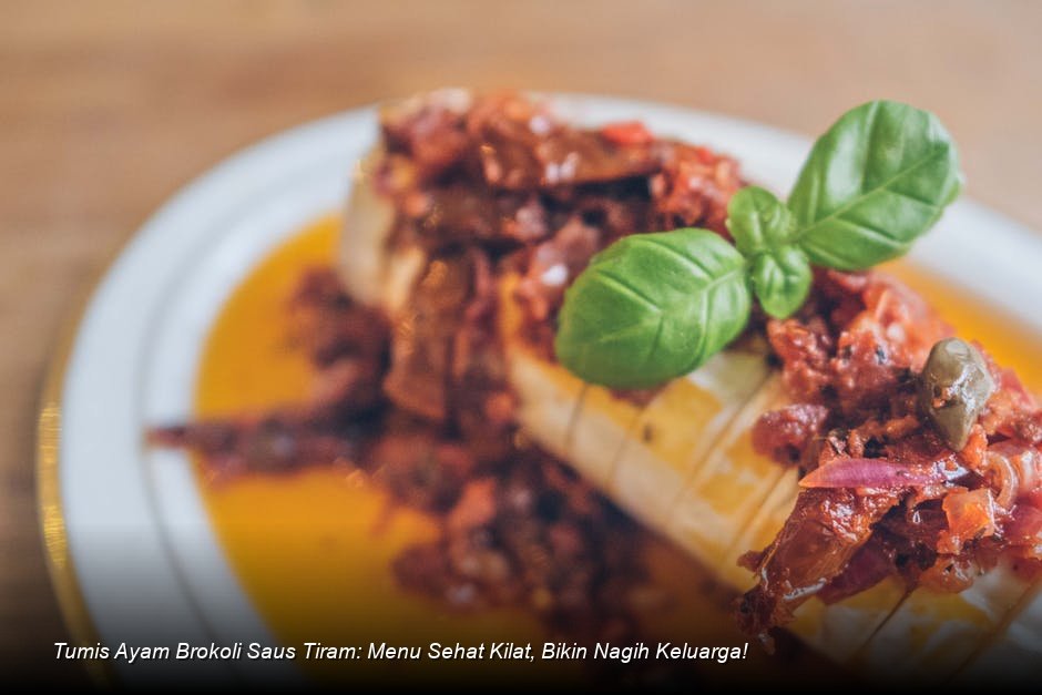 Semangkuk penuh Tumis Ayam Brokoli Saus Tiram yang mengkilap dengan taburan irisan daun bawang segar di atasnya.